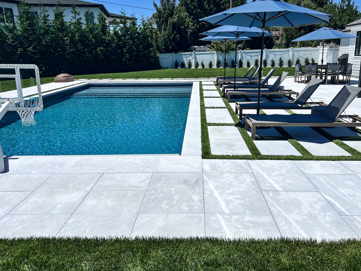 A pool with chairs and umbrellas.