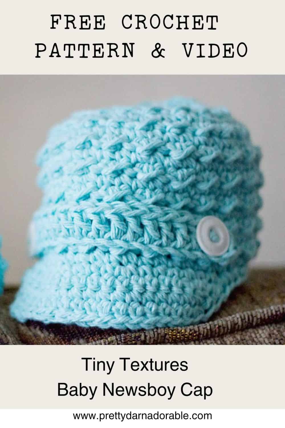 a crocheted blue newsboy cap with a band and button on it