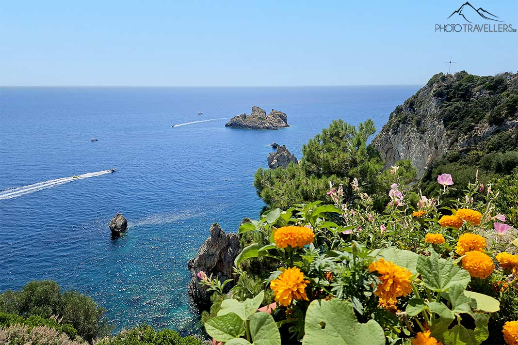 Blick vom mit Blumen gesäumten Felsen am Kloster Paleokastritsa auf das Meer