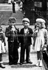 children eating ice cream 1946 Children eating ice cream in front of a fence, vintage black and white photo.