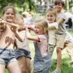 Importanta socializarii pentru copii Group of kids playing tug of war