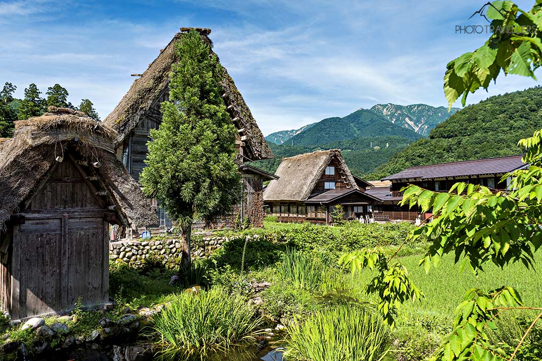 Zwei Häuser mit den typischen Dächern im Dorf Ogimachi, im Hintergrund Berge