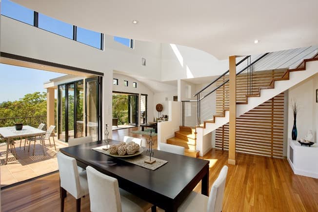 Interior view of a contemorary home designed by Herbert Nagel Design, with high void above living room and polished timber floors.