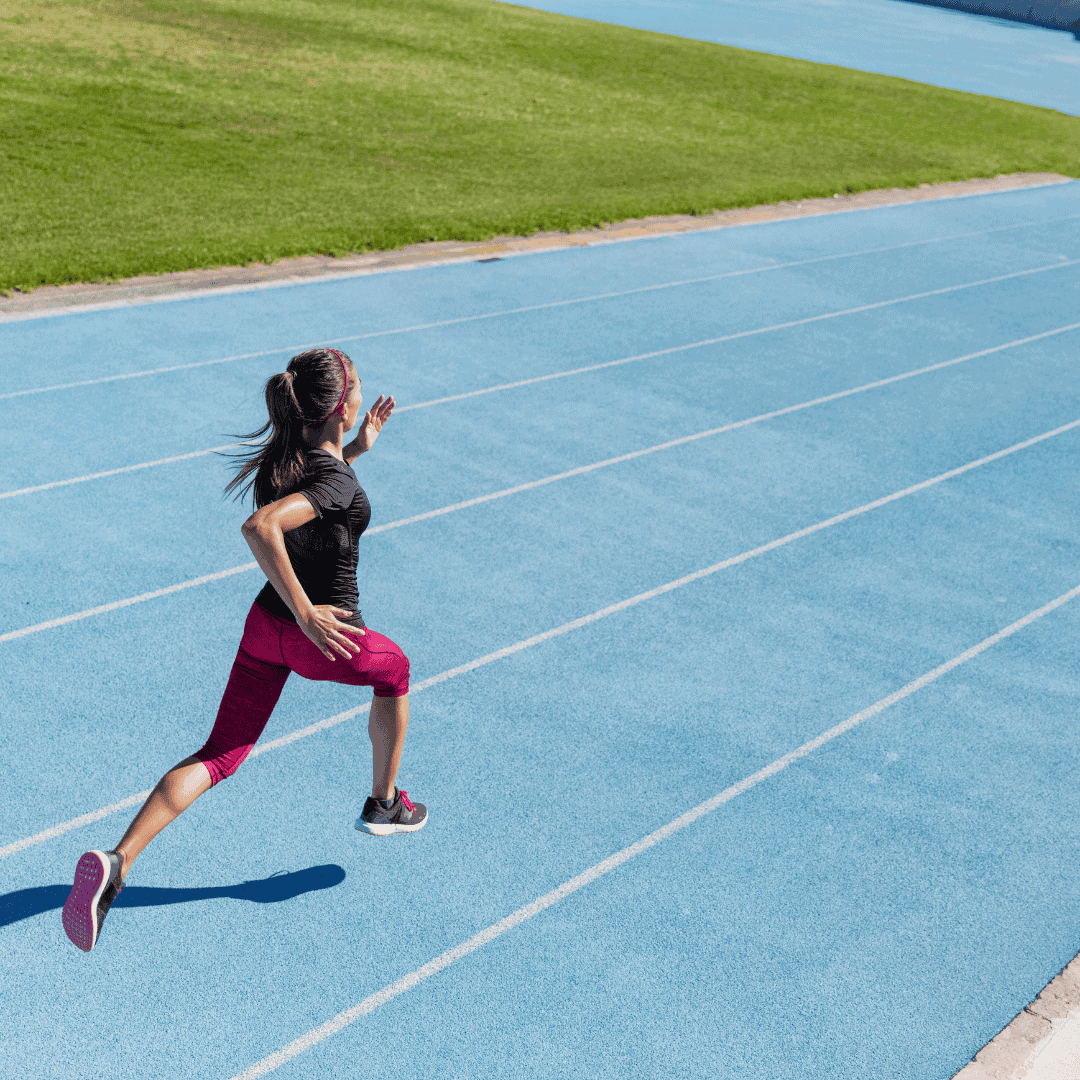Woman running on blue outdoor track