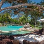 A group of lawn chairs sitting next to a pool of water