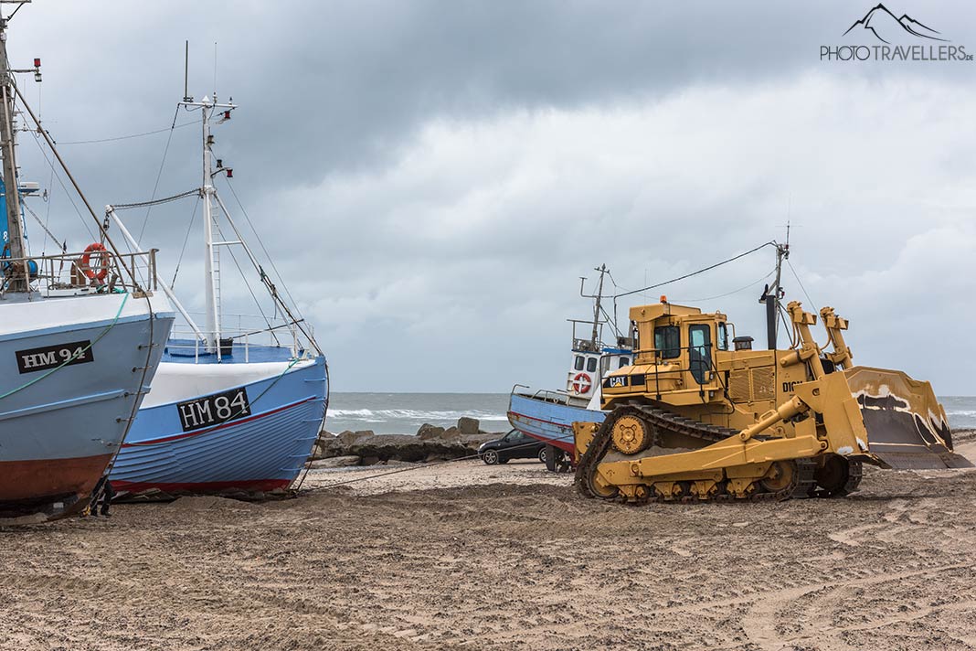 Ein Bulldozer zieht im Ort Thorup Strand ein Fischerboot an den Strand