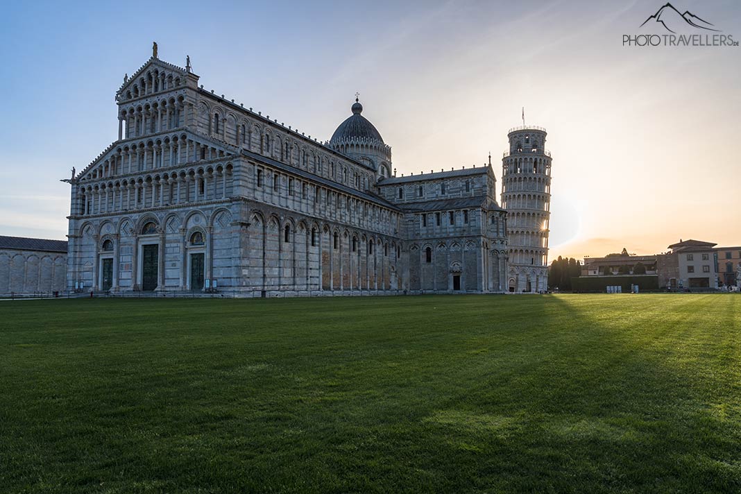 Der Dom Santa Maria Assunta mit dem Schiefen Turm von Pisa am Morgen, dahinter geht die Sonne auf