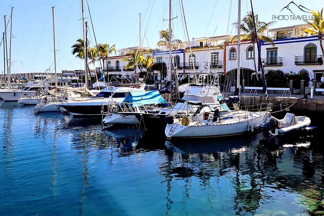 Segelboote ankern im mit Palmen gesäumten Hafen von Puerto de Mogan
