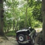 A car parked on pavement near a forest