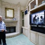 A person standing in front of a television