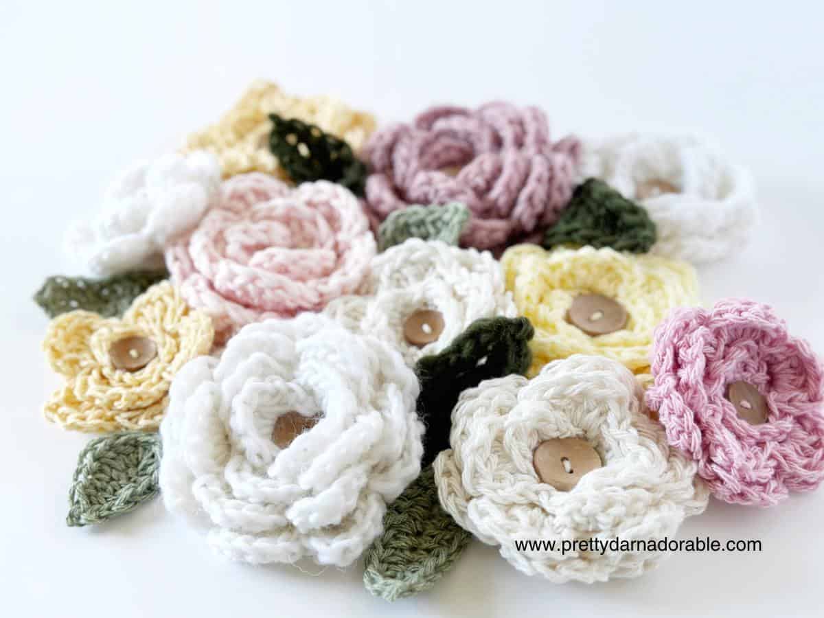 crochet roses in different colours with crochet leaves and buttons