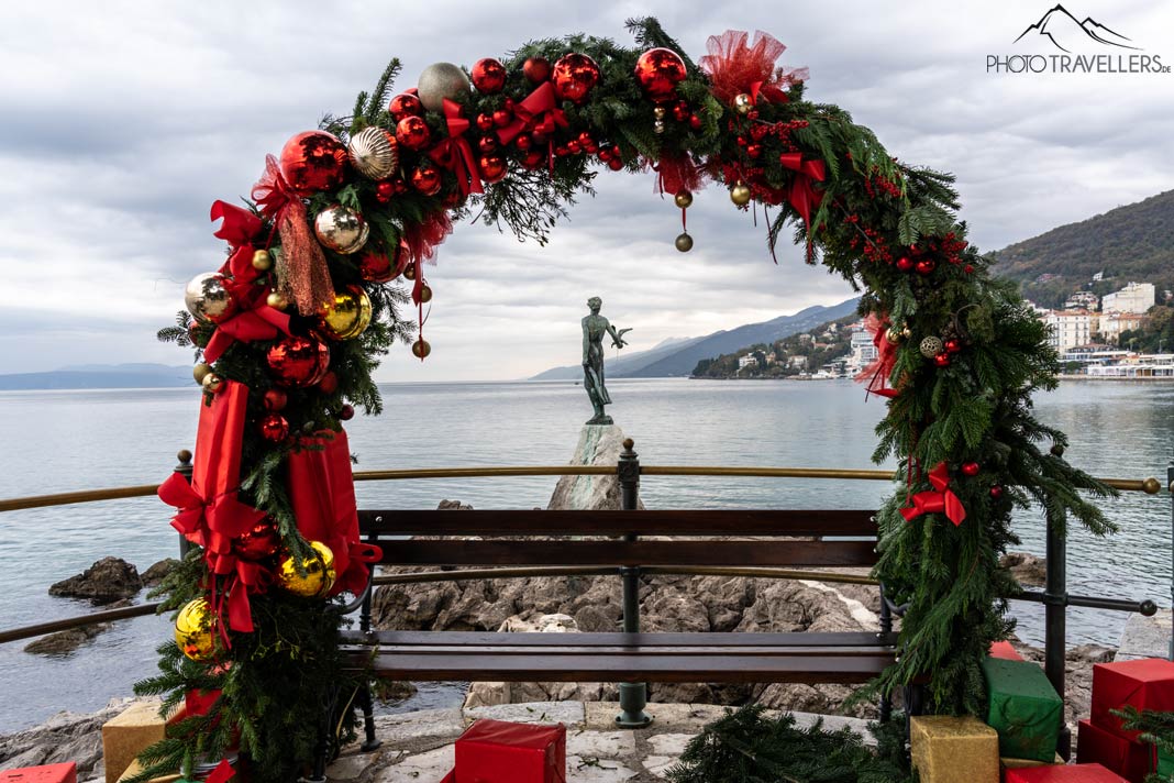 Die Statue "Mädchen mit Möwe" in Opatija mit Weihnachtskranz