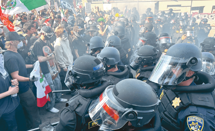 CHP officers push back protesters blocking the 101 Freeway entrance in downtown Los Angeles during ICE protests