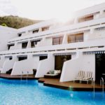 A blue and white boat sitting next to a pool of water