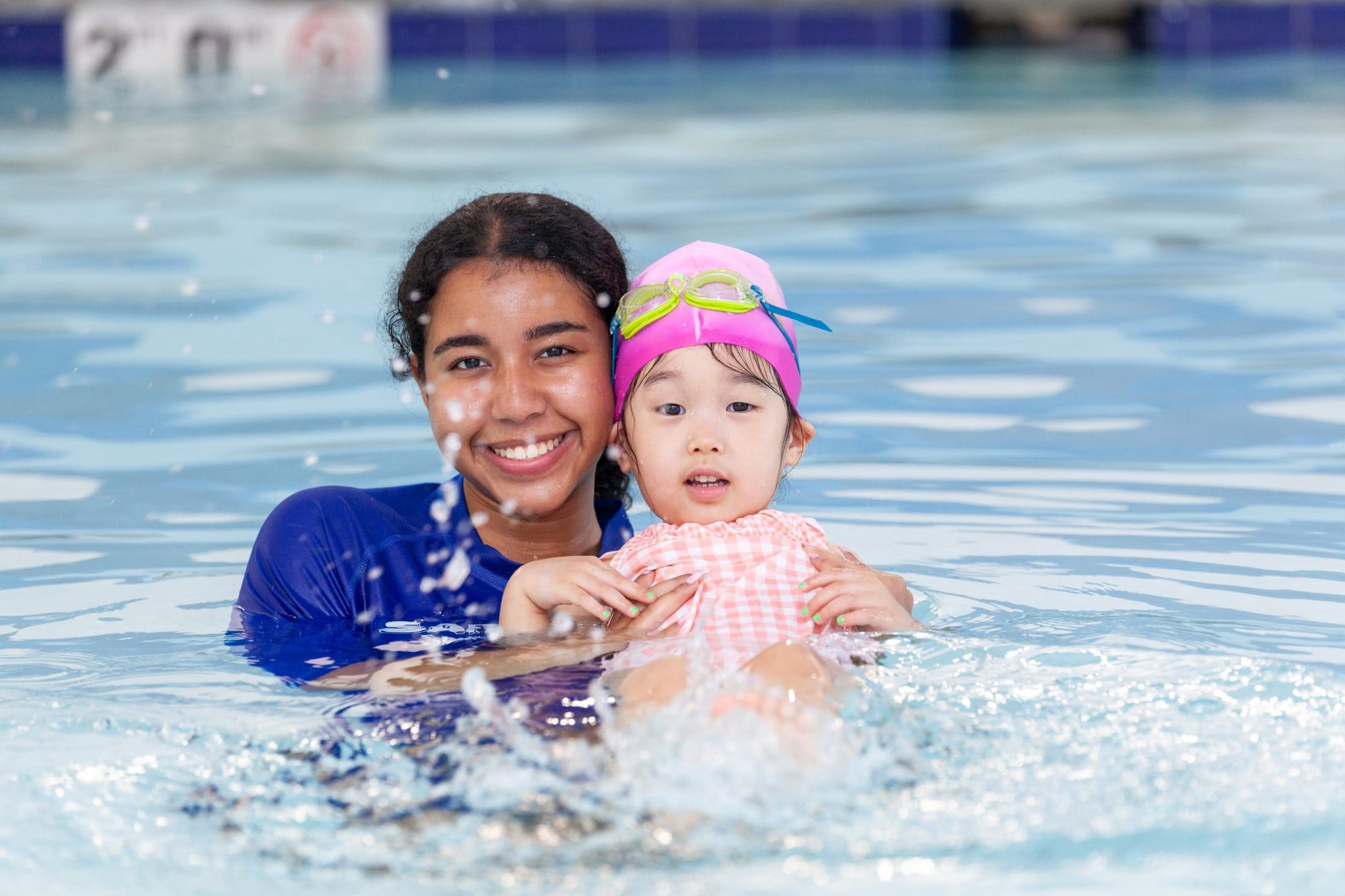 SafeSplash instructor supports a young swimmer practicing a back float during a lesson