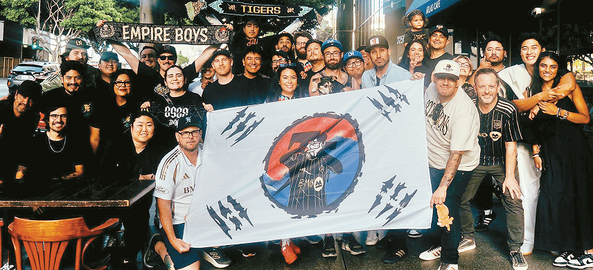 TSG members in Koreatown hold a Taegukgi with Son Heung-Min celebration after watching his first start against New England