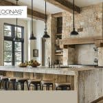 Cocina rústica con isla en madera reciclada, muros en piedra natural y luminarias de hierro