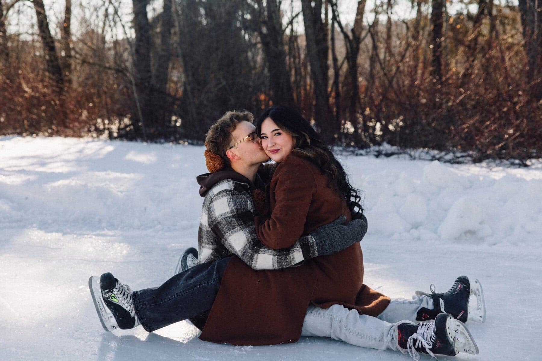 couple sitting with each other on ice rink