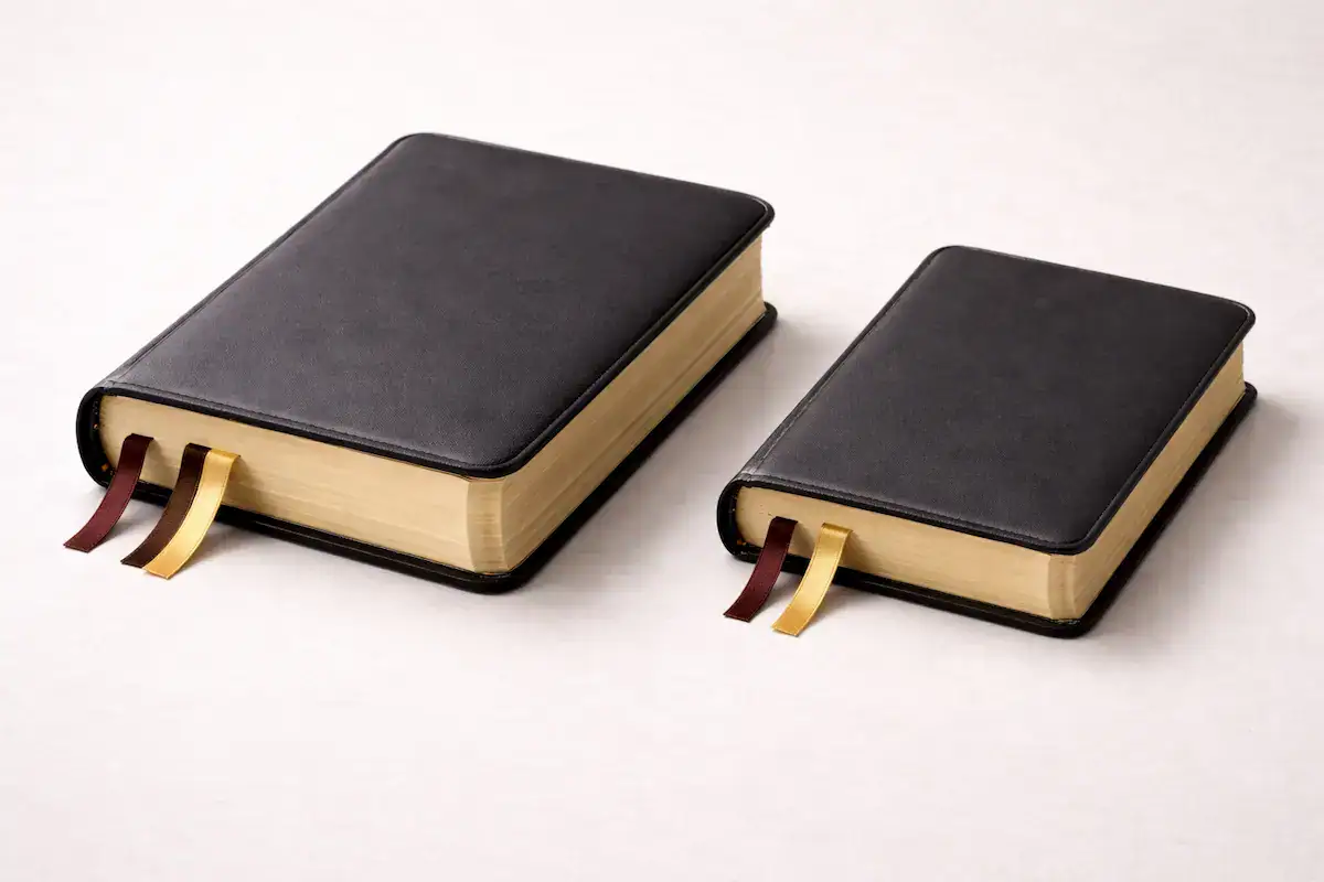 Two closed Bibles placed side by side, showing visible differences in thickness and height.