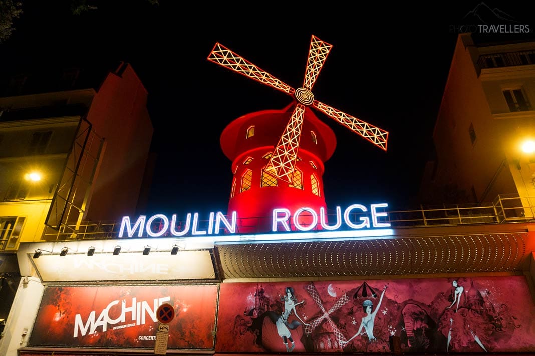 Die bekannte Fassade des Moulin Rouge mit der rot angestrahlten Windmühle in Paris