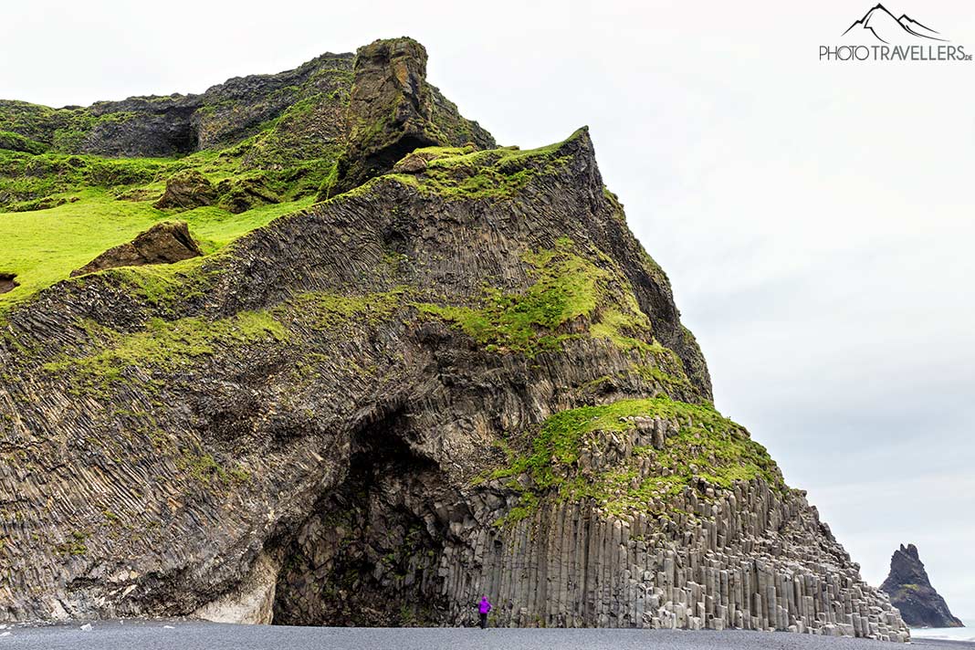 Reisebloggerin Biggi Bauer vor den riesigen Basaltfelsen am Strand von Strand von Reynisfjara in Island