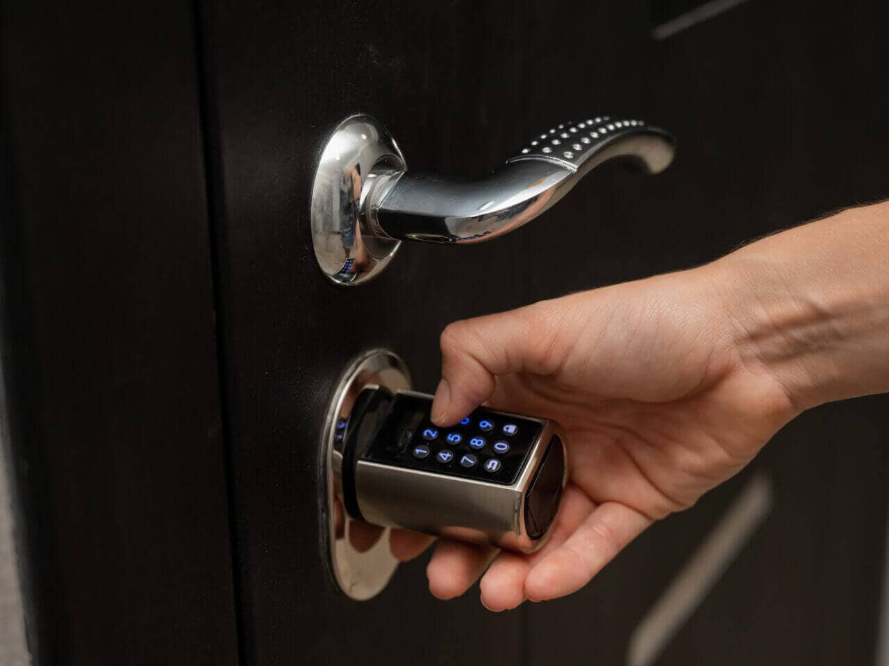 A person opening a smart deadbolt lock
