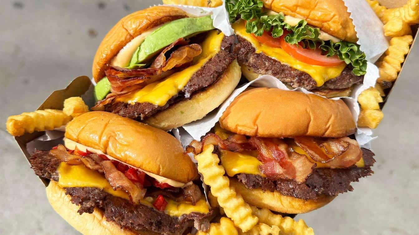 Free Shake Shack burger promotion with stacked burgers in a to-go brown paper box