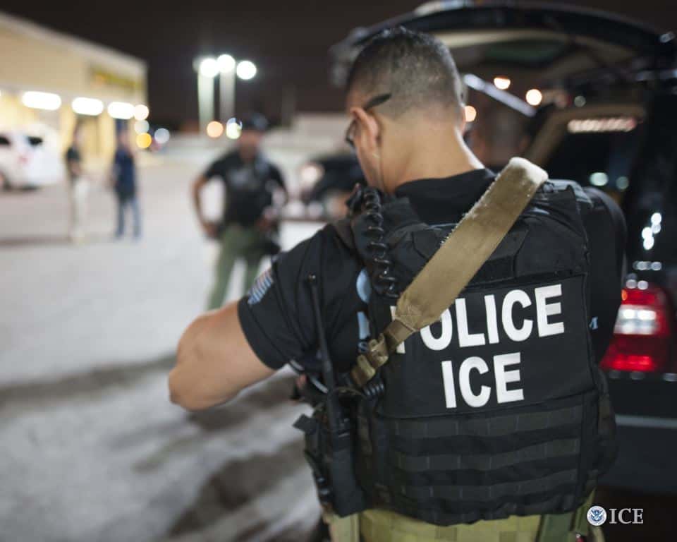 ICE agent in vest during immigration enforcement, related to Korean undocumented immigrants