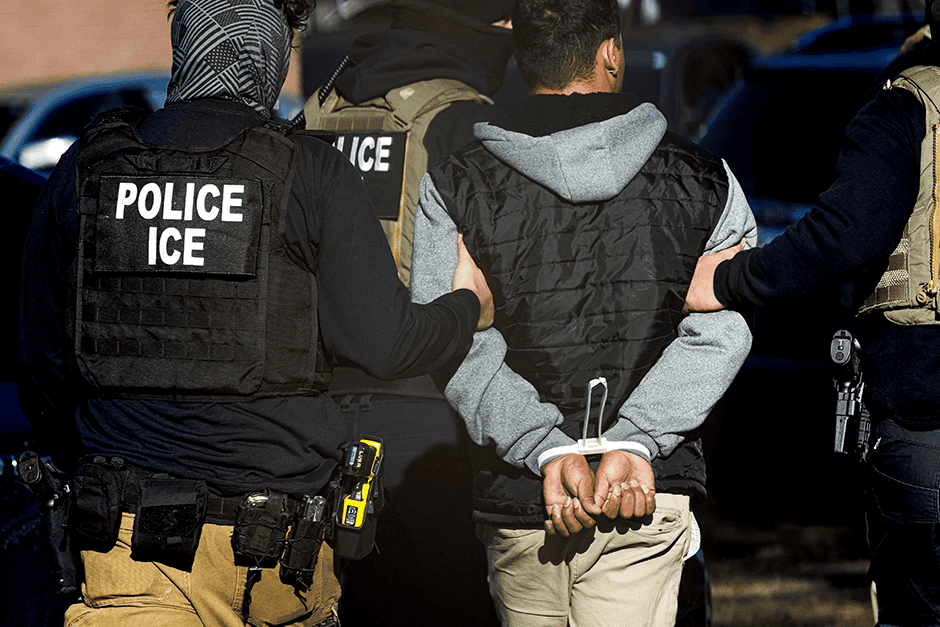 ICE agents wearing vests arresting a person during immigration raids on restaurants