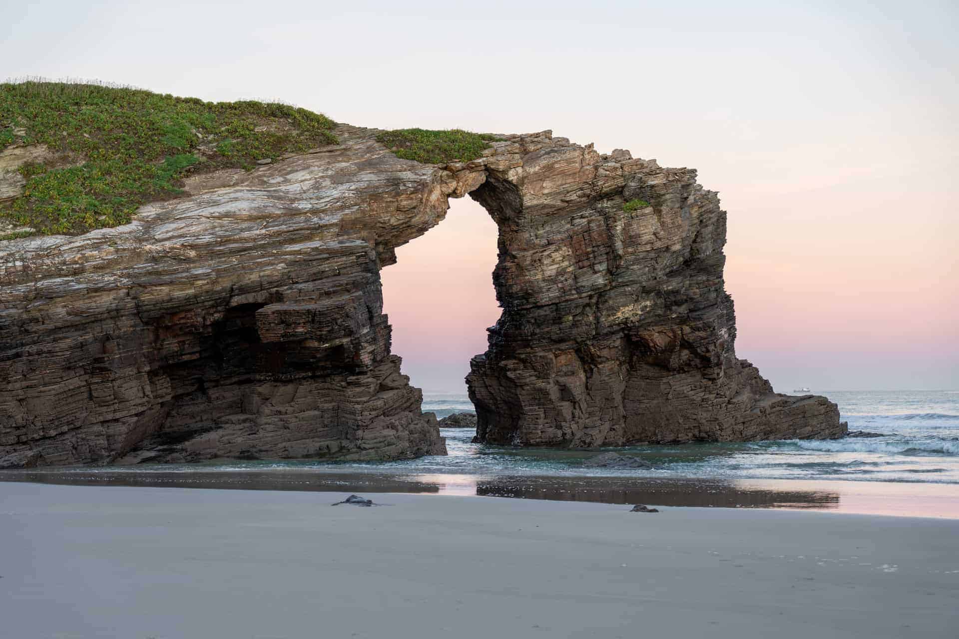 Felsbogen As Catedrais in Galicien bei Sonnenaufgang Felsbogen As Catedrais in Galicien bei Sonnenaufgang