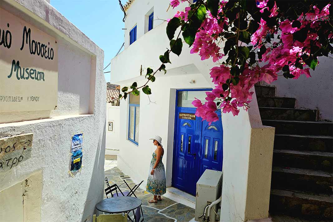 Weiße Häuser mit blauen Türen und pinkfarbener Bougainvillea säumen die Gassen von Dryopida