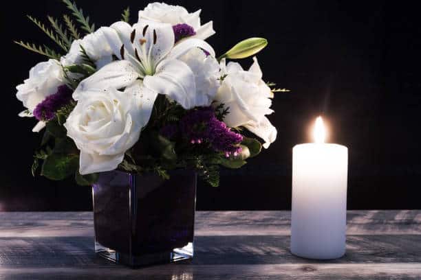 Flower Sympathy Gifting in Scotland A sympathy flower in a vase beside a lighted candle