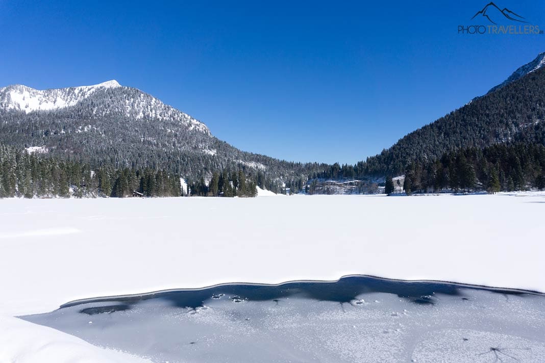 Der zugefrorene Spitzingsee im Winter mit den verschneiten Bergen dahinter