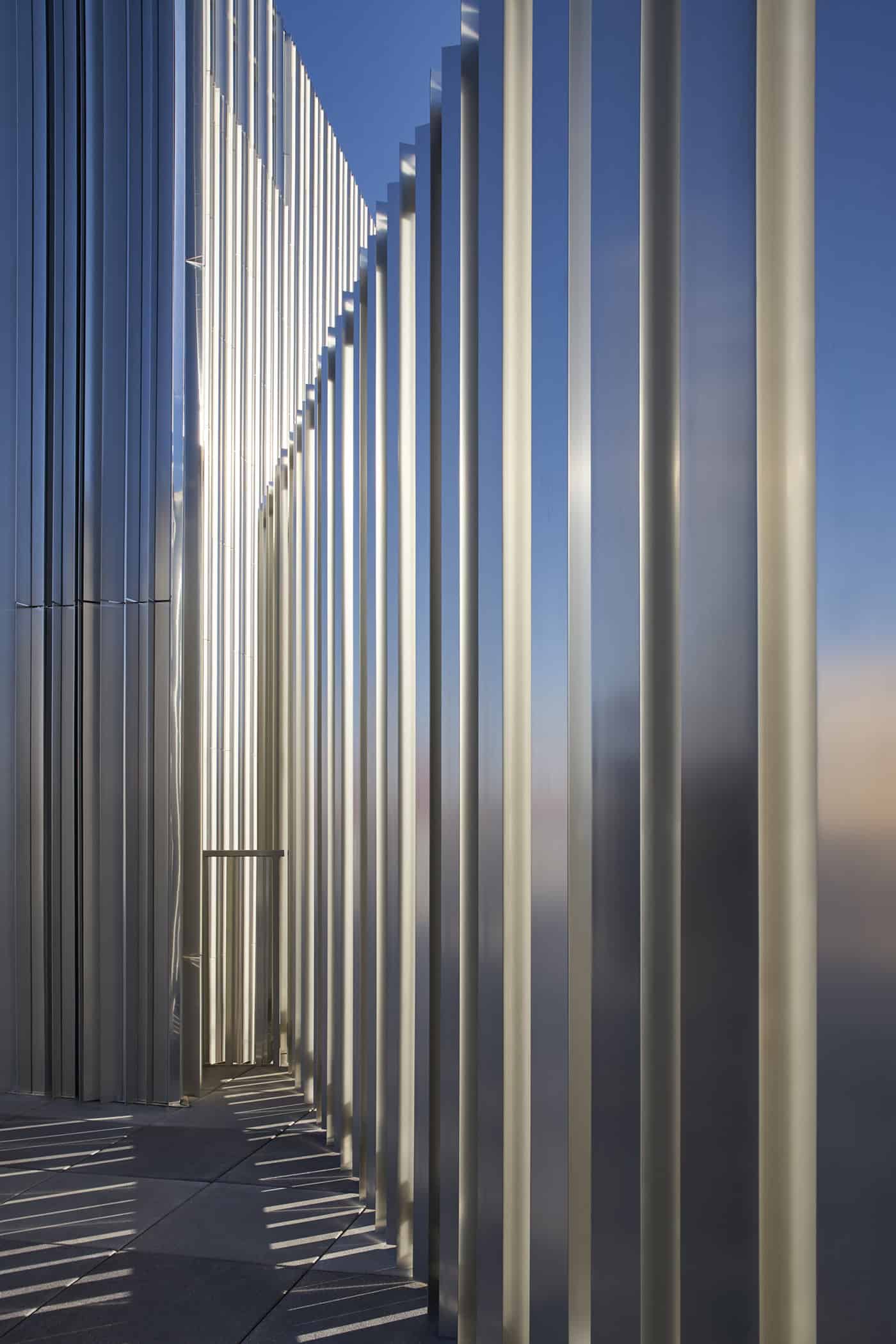 Vertical aluminum fins of the Oklahoma Contemporary Arts Center cast shadows and reflections, creating a dynamic interplay of light and space.
