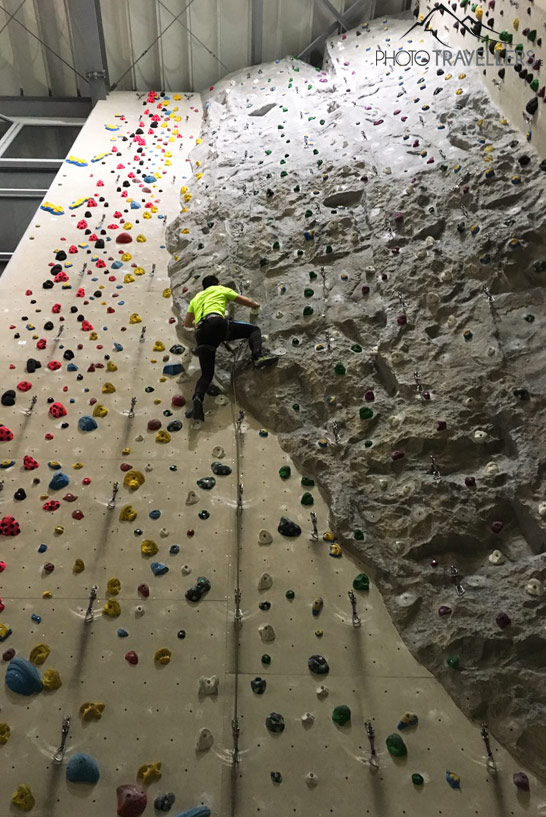 Reiseblogger Florian Westermann an einer hohen Wand in der Kletterhalle