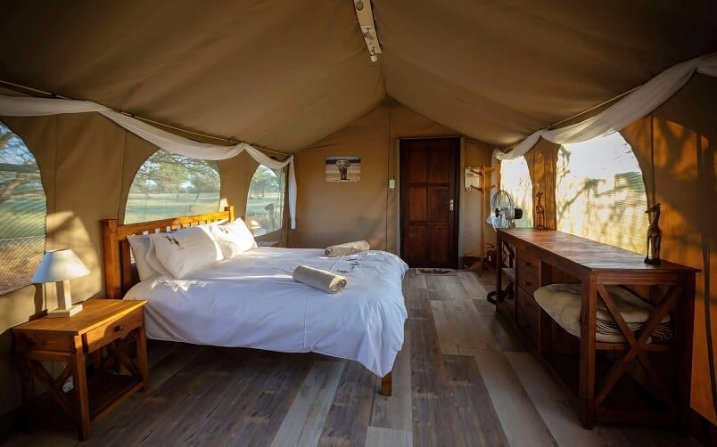 kalahari-conservation-safari-tent-accommodation Queen bed inside a luxury tented camp, Kalahari Desert