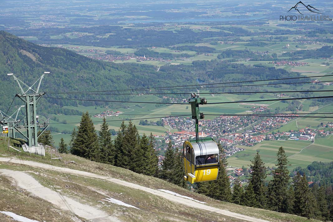 Eine gelbe Gondel der Kampenwandseilbahn mit Blick ins Tal