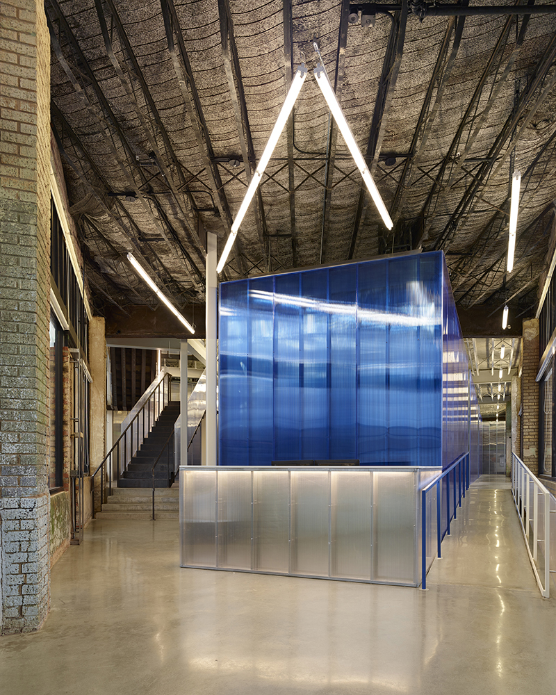 Interior lobby of PLICO at the Flatiron with translucent blue partitions