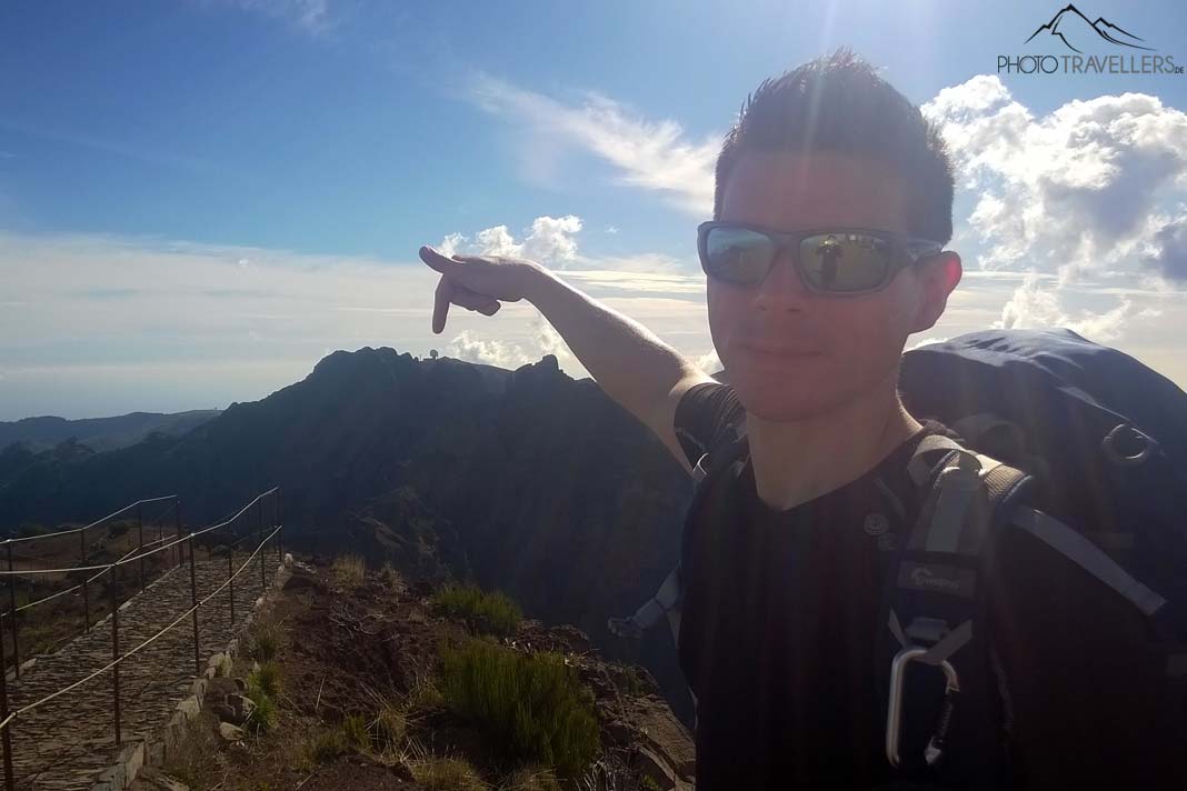 Reiseblogger Florian Westermann zeigt mit dem Finger zur Radarstation auf dem Pico do Arieiro