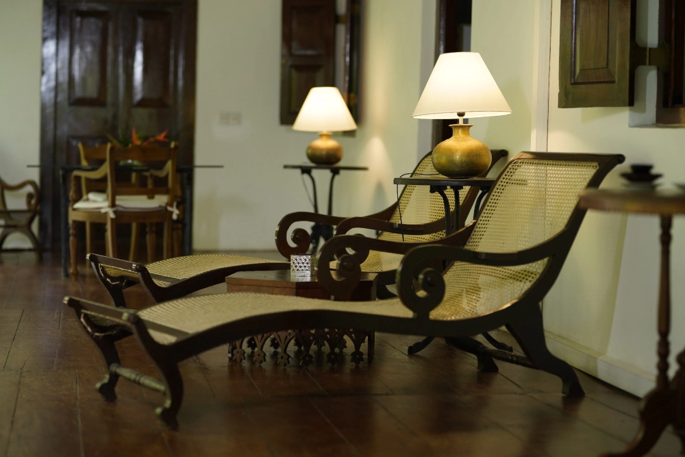 A serene space in Adigar's manor, the featuring two chairs and a lamp, outside the Connelian room, perfect for relaxation.