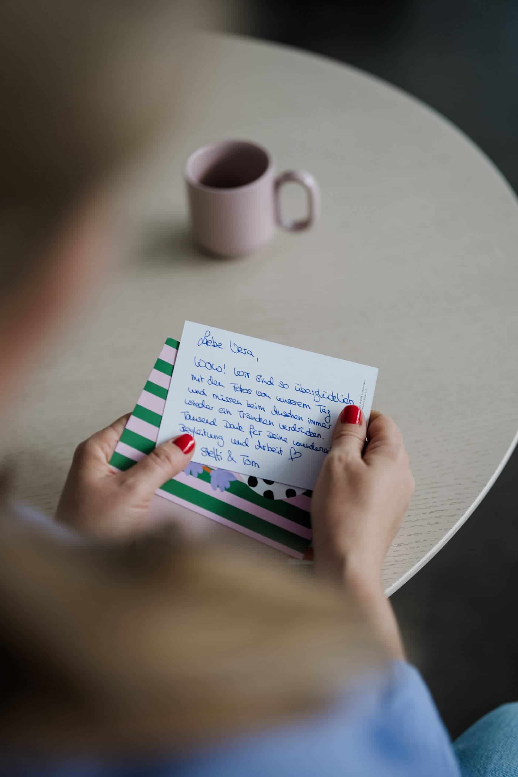 Foto als Link zur Unterseite Testimonials Hochzeitsfotografin Vera blättert durch Fotobuch beim Shooting in Köln