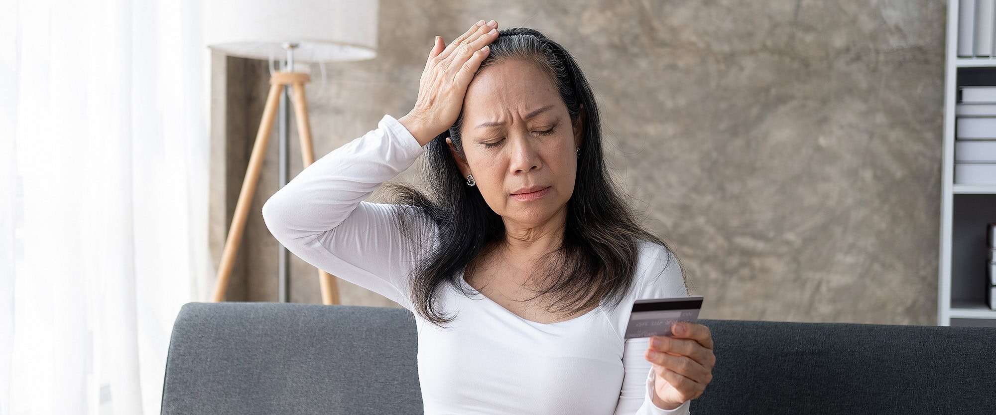 Mujer frustrada y molesta por la deuda de su tarjeta de crédito.