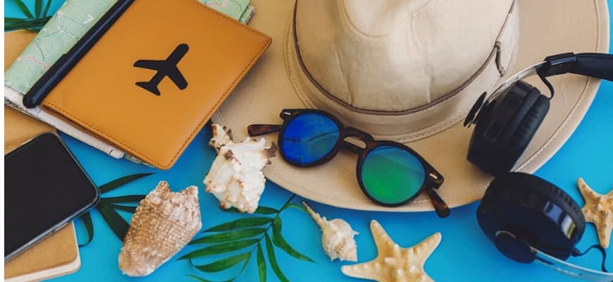 Summer hat, notebok, shades, shells in blue printed background