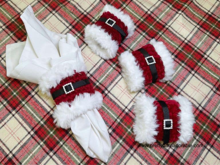 red napkin ring with white fur trim with black belt and rhinestone buckle