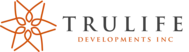The image shows the logo for Trulife Developments Inc. It features an abstract orange star-like design on the left, reminiscent of a locksmith's intricate key, and the company name "TRULIFE" in large black letters, with "DEVELOPMENTS INC" in smaller orange letters underneath.