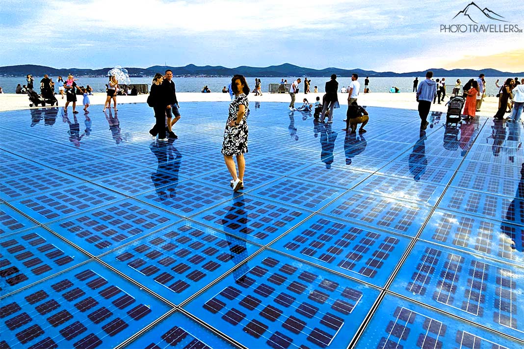 Menschen stehen auf dem blauen Glasboden an der Promenade von Zadar