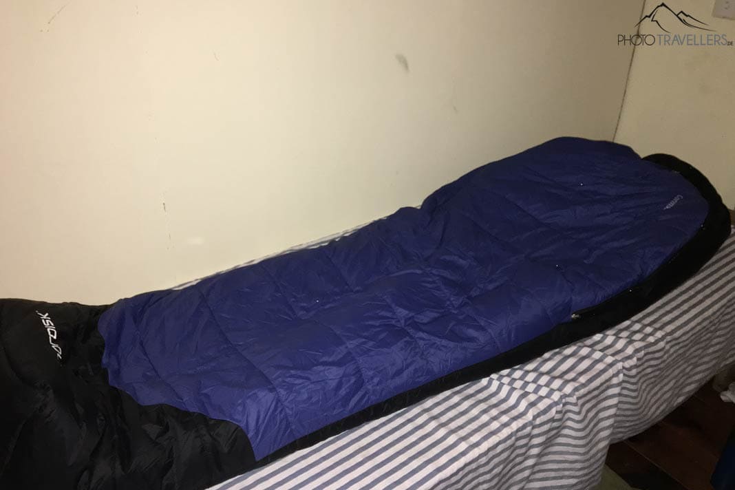 Ein blauer Schlafsack auf einem Bett in einer Lodge in Nepal