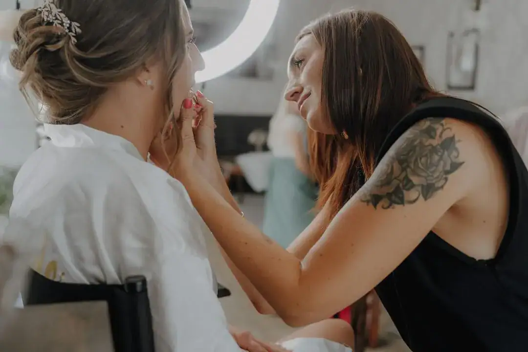 Absolventin der Famous Face Academy Sarah Salvador schminkt eine Frau vor einem Ringlicht