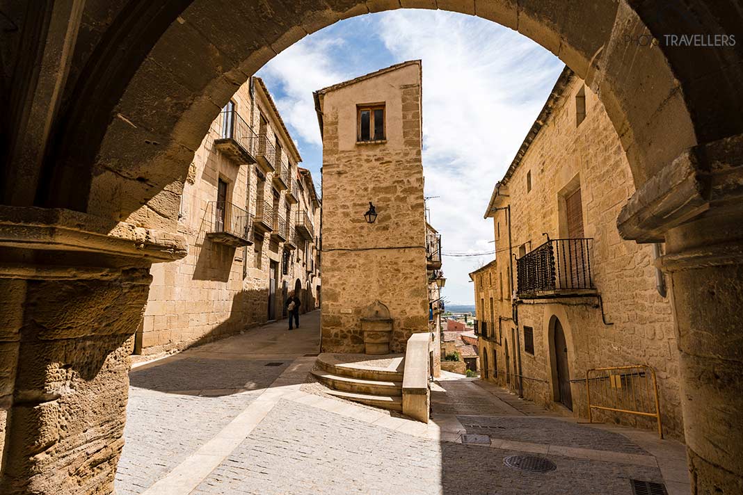Der Blick durch einen Torbogen mit einem Haus dahinter in Calaceite