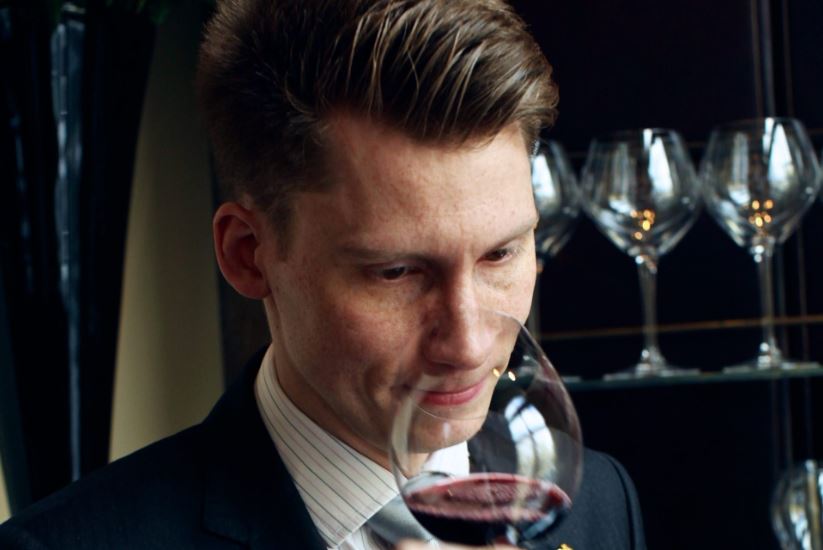 Man tasting red wine at a wine tasting at the winery.